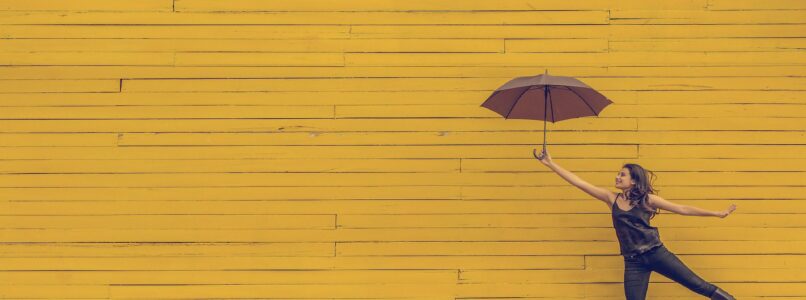 woman leaping with umbrella held in the air