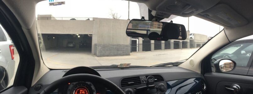 dash cam on rearview mirror, seen from car interior, looking through front windshield